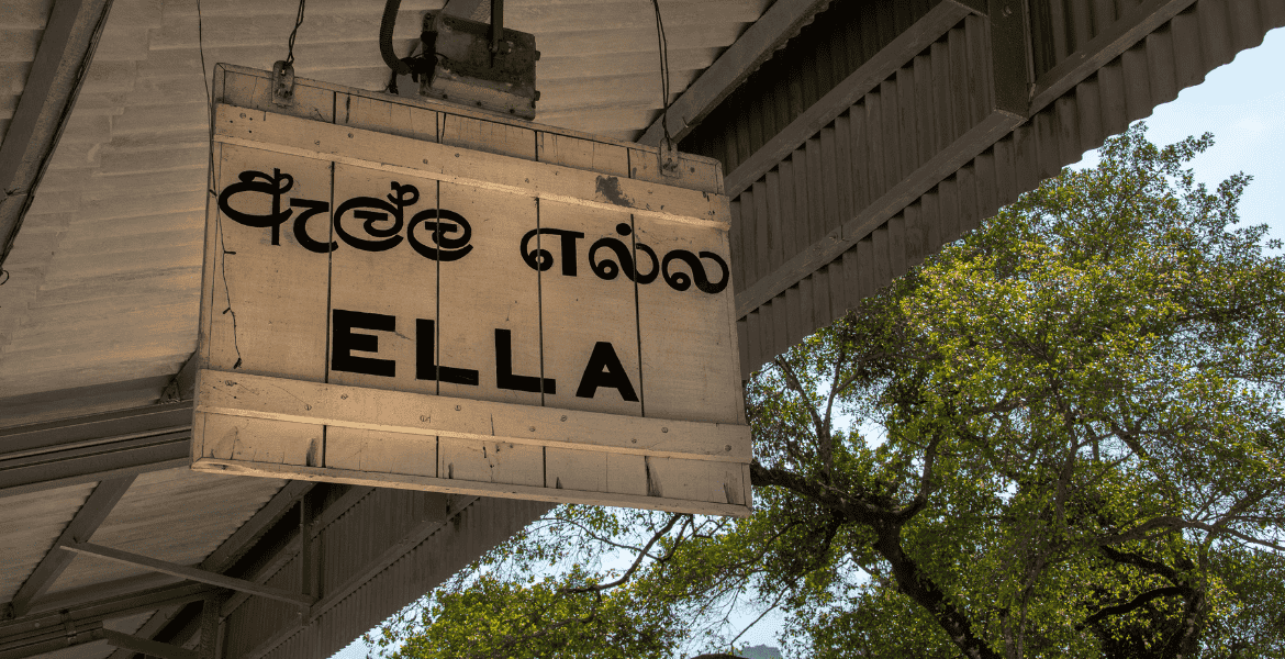 Ella railway station name board displayed in Sinhala, Tamil, and English, marking a popular walking spot in the heart of Ella town, Sri Lanka.