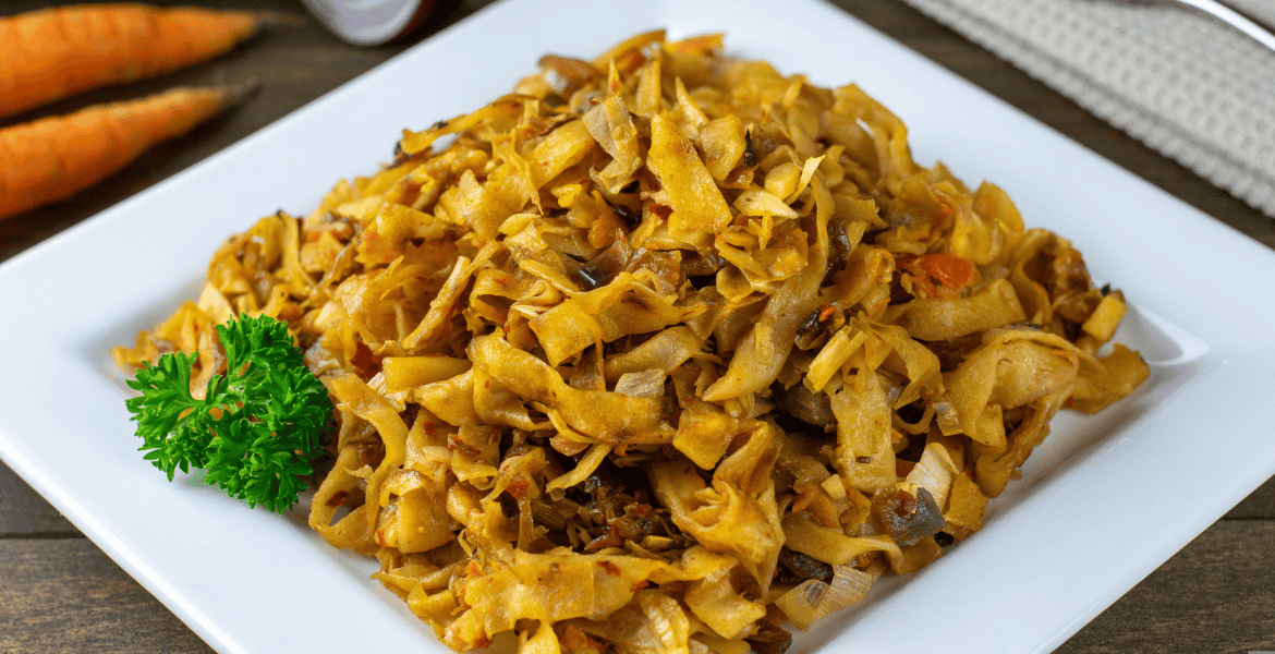 A plate of sizzling Sri Lankan kottu roti, made with chopped flatbread, vegetables, eggs, and aromatic spices – served hot in Ella, Sri Lanka.